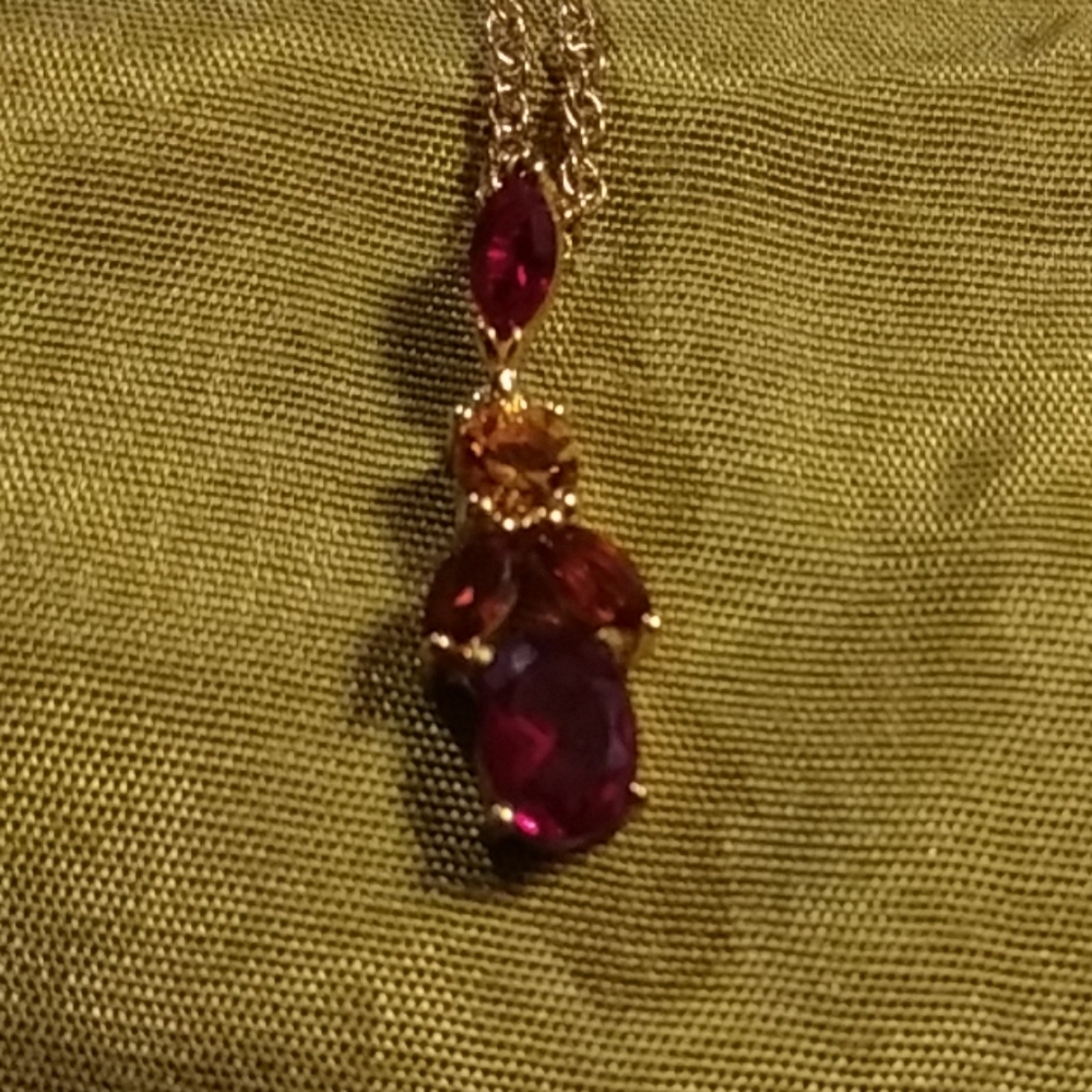 Multi colored gems in gold chain is gold accented